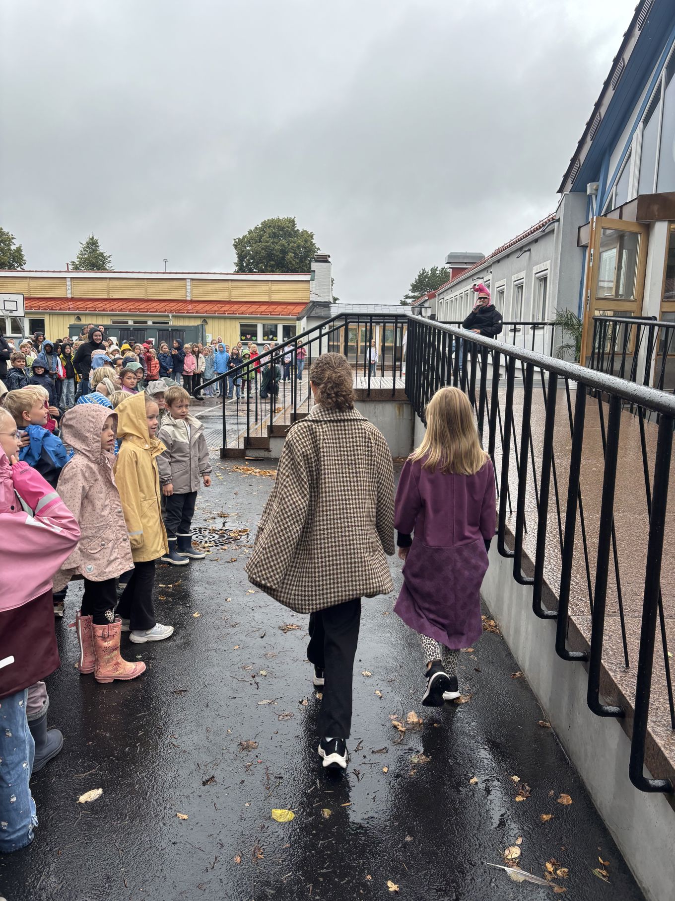 en gruppe mennesker som står i en gate med en stor metallkonstruksjon en gruppe mennesker som står i en gate med en stor metallkonstruksjon